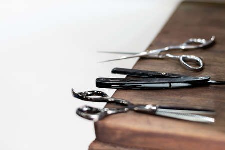 Scissors and barbers razor in detail, isolated on a table. Work instruments