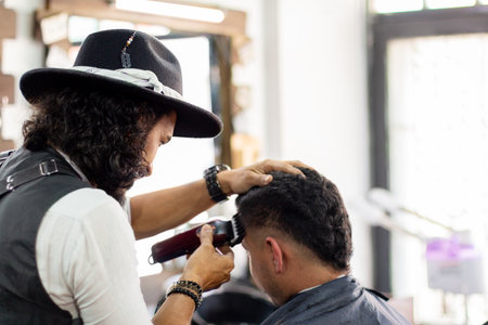Barber using hair clipper on client. Hipster stylist. Hair Stimulation growthの写真素材