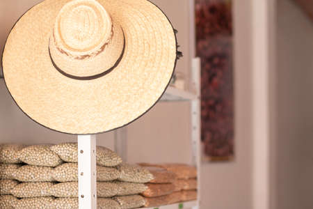 Peas, lentils. Grain store with Colombian peasant hat. Store shelf of grains stored in transparent bagsの写真素材
