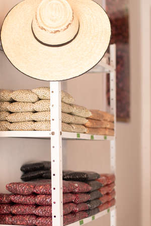 Peas, lentils. Grain store with Colombian peasant hat. Store shelf of grains stored in transparent bags. Vertical photoの写真素材