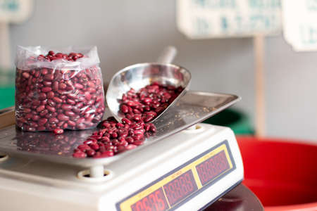 Red beans on balance. Beans in bag and metal shovel. Spilled beans.の写真素材