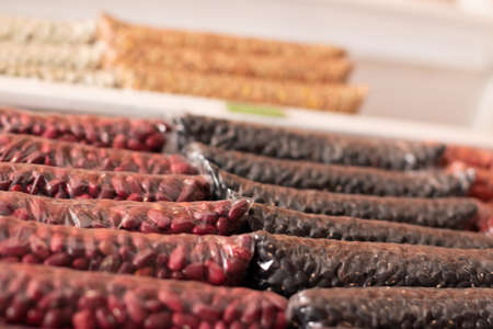 Red and black beans stacked in bags. Transparent bags. Dry bean store.の写真素材