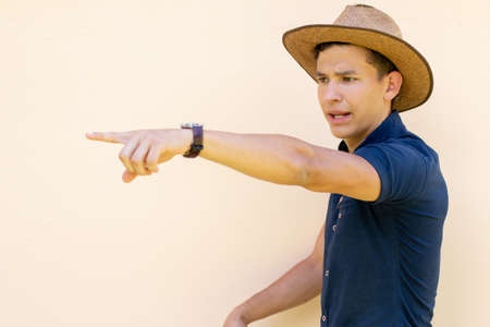 An angry male farmer gesturing with his hand giving orders. Concept of man on white background. Beige background.の写真素材