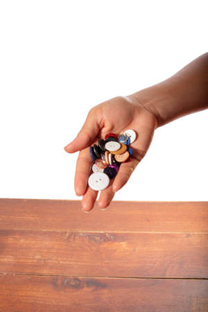 Hand full of clothes buttons. Hand isolated on white background.の写真素材