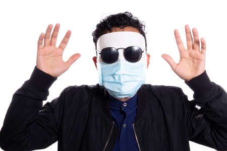 Man in disguise scaring and wearing face mask. White background. Wearing sunglasses.の写真素材