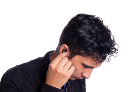 Man putting on headphones isolated on white background. Young latino guy using or putting on...