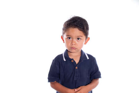 Little boy with look of sadness and regret, isolated on white background. Latin child afraid of being punished. Being reprimanded.の写真素材