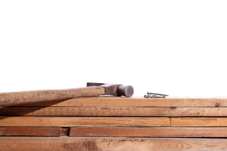 Hammer and nails on wooden boards, isolated on white background. Concept of carpentry. Carpentry tools.の写真素材