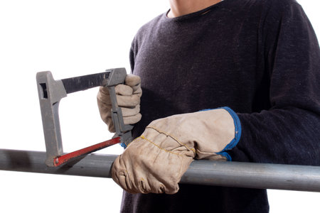 Man cutting iron pipe with hand saw, isolated on white background. Unknown person sawing steel pipe....