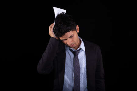 Worried, stressed and bored businessman succumbing to stress. Young adult latin man worried about his job. Confused man.の写真素材