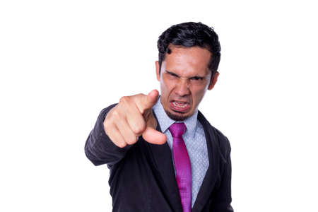 Bad business manager pointing at the camera with an angry and displeased face. Businessman shouting and pointing at the camera. Nasty boss isolated on white background.の写真素材