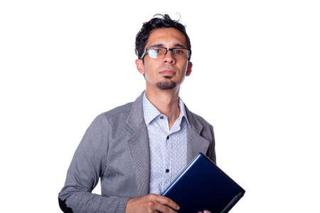 Young modern businessman holding laptop with his hands and looking at camera. man wearing glasses isolated on white background.の写真素材