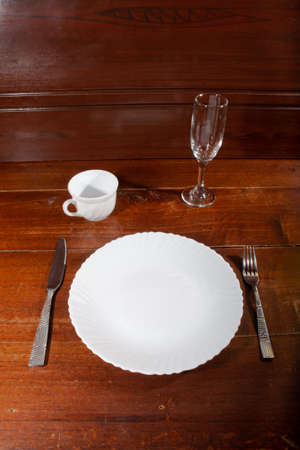 empty plate spoon fork and knife on tableの写真素材