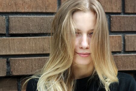 Beautiful woman standing against wall in background の写真素材
