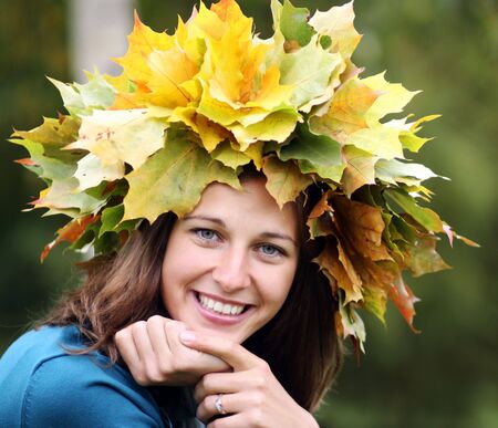 Beautiful woman with diadem made from yellow maple leaves の写真素材
