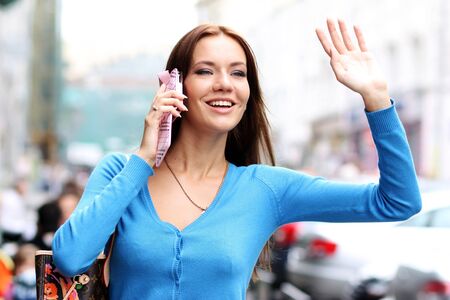 Happy young lady talking on mobile phoneの写真素材