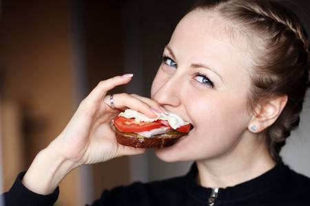 Beautiful young woman eating hamburger の写真素材