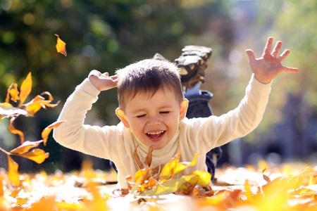 5 years old child lying on the golden leafの写真素材