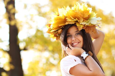 young beautiful girl with a bouquet of maple leavesの写真素材