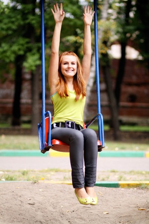 Woman on country garden swing の写真素材