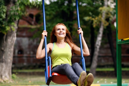 Woman on country garden swing 
