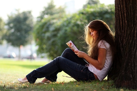 portrait of young beautiful woman reading magazine の写真素材