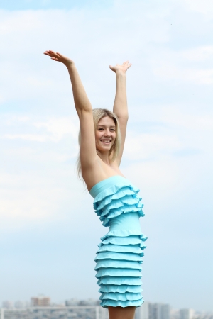 Young blond woman in sexy dress on background of the skyの写真素材