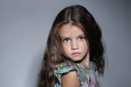 close up portrait of young beautiful little girl with dark hairの写真素材