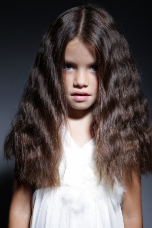 close up portrait of young beautiful little girl with dark hairの写真素材