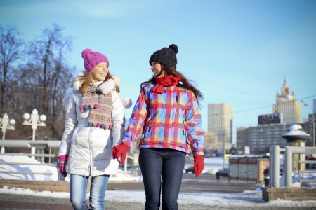 Happy young couple women in winter streetの写真素材
