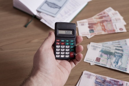 Male hand holding a calculatorの写真素材