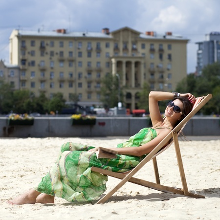 Young beautiful woman relaxing lying on a sun loungerの写真素材