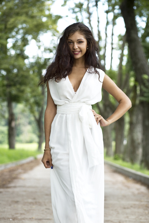 Happy woman in a white dress on the streetの写真素材