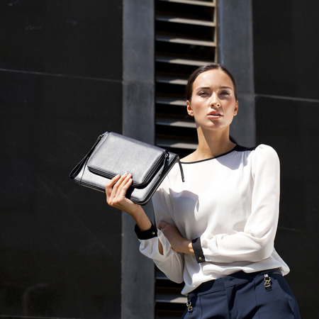 Young beautiful brunette woman with a bag in his handの写真素材