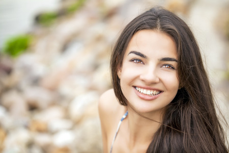 Portrait close up of young beautiful woman, on green background summer natureの写真素材