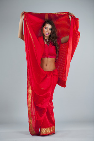 Full body cheerful traditional Asian Indian woman in indian sari, isolated on gray backgroundの写真素材