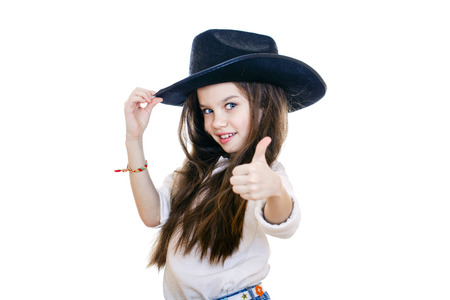 Portrait of a beautiful little girl in a black cowboy hat, studio on white isolated backgroundの写真素材