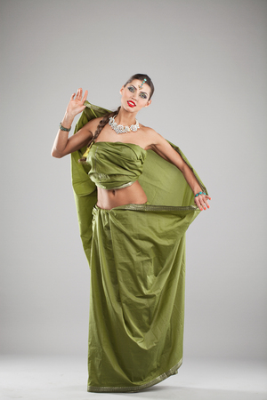 Young beautiful brunette woman in indian green dressの写真素材