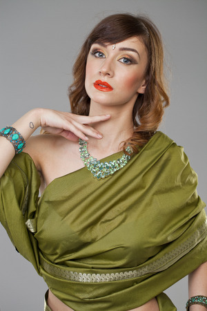 Young beautiful brunette woman in indian green dress