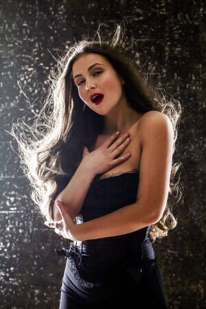 Beauty portrait of young attractive woman, isolated on dark studio