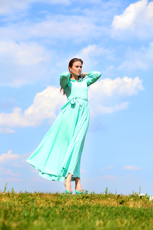 Portrait in full growth, attractive young woman in green dressの写真素材