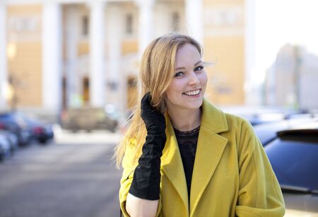 Portrait close up of young beautiful blonde woman, on spring street backgroundの写真素材