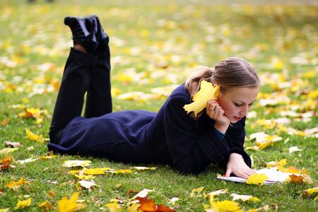 Beautiful young woman in autumn parkの写真素材