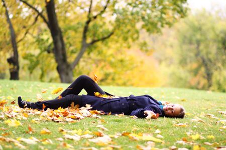 Beautiful young woman in autumn parkの写真素材