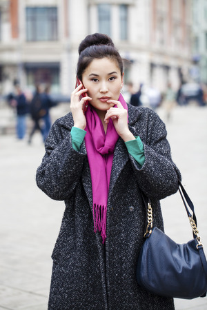 Asian beautiful girl calling by phone in spring streetの写真素材