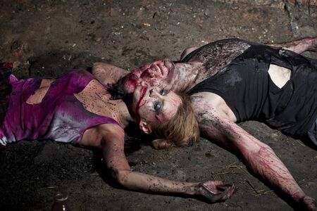 Couple of bloody man and woman lying on the groundの写真素材