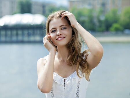 Close up Portrait, Young beautiful blonde woman in green dress posing outdoors in sunny weatherの写真素材