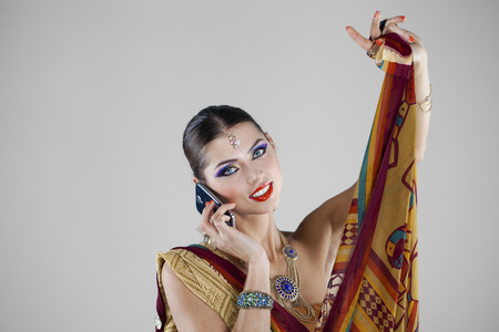 Young traditional Asian Indian woman calling by phoneの写真素材