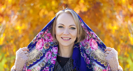 Portrait close up of young beautiful woman on background of autumn park