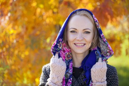 Portrait close up of young beautiful woman on background of autumn parkの写真素材
